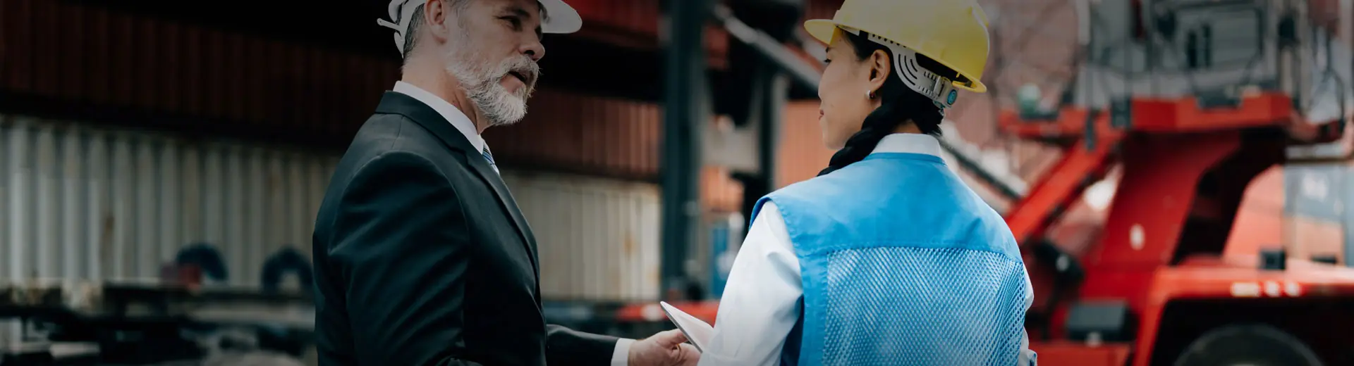 Transportation professional talking to a female Direct Right worker in container yard 